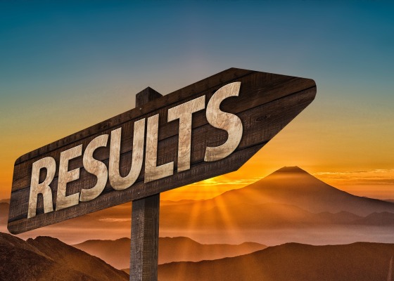 Arrow sign with the word "results" against a mountainous background and sunset.
