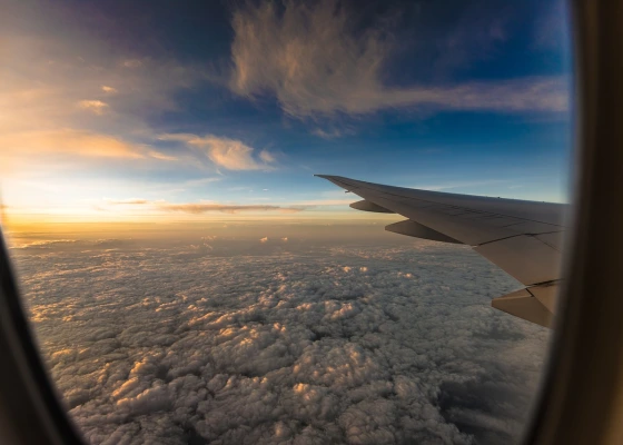 View of the aeroplane wing and clouds at sunset out of an aeroplane window. Image by Nikhil Kurian from Pixabay